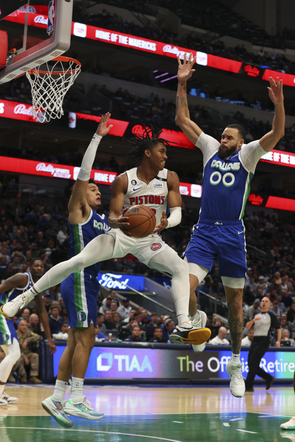 Detroit Pistons guard Jaden Ivey, center, looks to pass the ball as he is guarded by Dallas Mavericks guard Josh Green, left, and center JaVale McGee (00) in the first half of an NBA basketball game Monday, Jan. 30, 2023, in Dallas. (AP Photo/Richard W. Rodriguez)