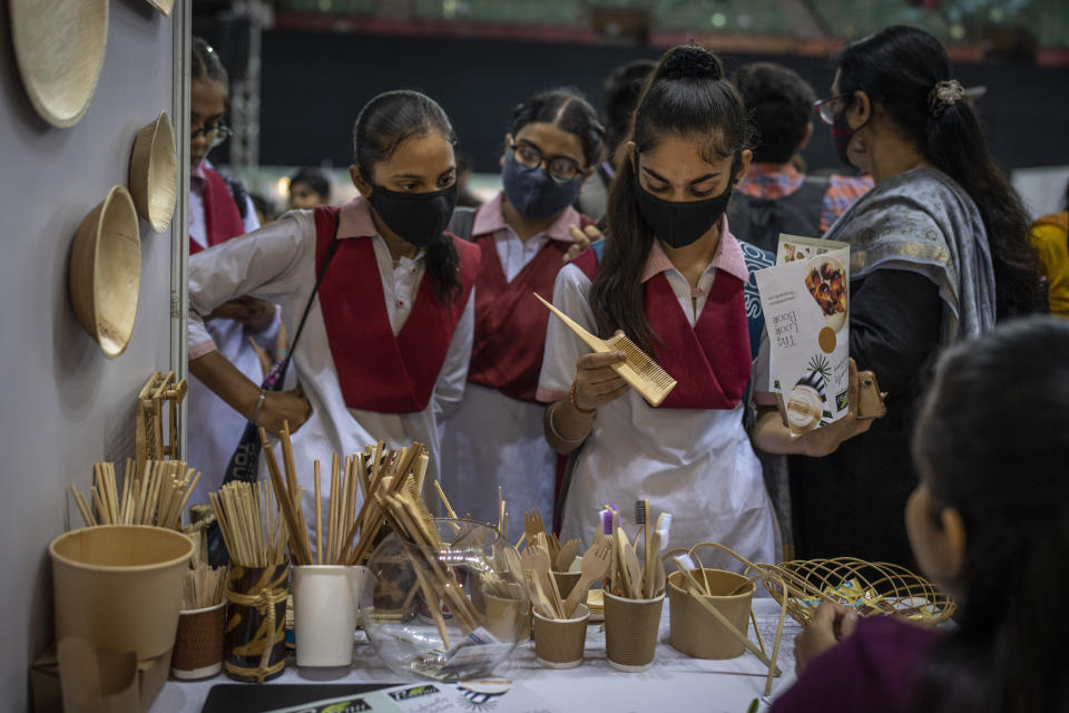 Schoolgirls look at items which are an alternate to plastic at an event to create awareness about eco-friendly products in New Delhi, India, Friday, July 1, 2022. India banned some single-use or disposable plastic products Friday as part of a federal plan to phase out the ubiquitous material in the nation of nearly 1.4 billion people. (AP Photo/Altaf Qadri)