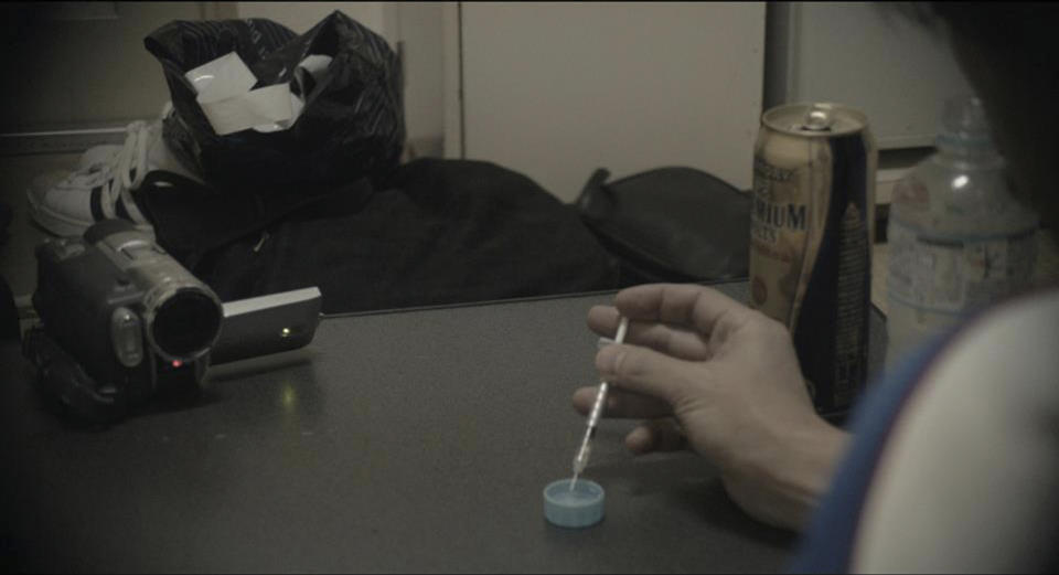 In this undated photo released by Japanese film director Shingo Ota, a drug dealer prepares to give an amphetamine injection to the protagonist, not shown, during a scene from the film "Fragile" filmed by Ota mainly in Kamagasaki, Osaka, western Japan. Japan’s biggest slum, Kamagasaki, is visible just blocks from bustling restaurants and shops in Osaka, the country’s second-largest city. But it cannot be found on official maps. Nor did it appear in the recent Osaka Asian Film Festival, after Ota pulled it, accusing city organizers of censorship. Osaka officials asked Ota to remove scenes and lingo that identify the slum, on the grounds that it was insensitive to residents. (AP Photo/Shingo Ota)