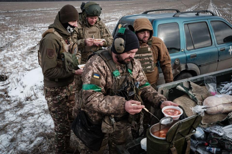 Ukrainian servicemen of the artillery unit of the 80th Air Assault Brigade serve themselves delivered borsch, near Bakhmut on Feb.7, 2023 amid the Russian invasion of Ukraine. (Photo by Yasuyoshi Chiba/AFP via Getty Images)