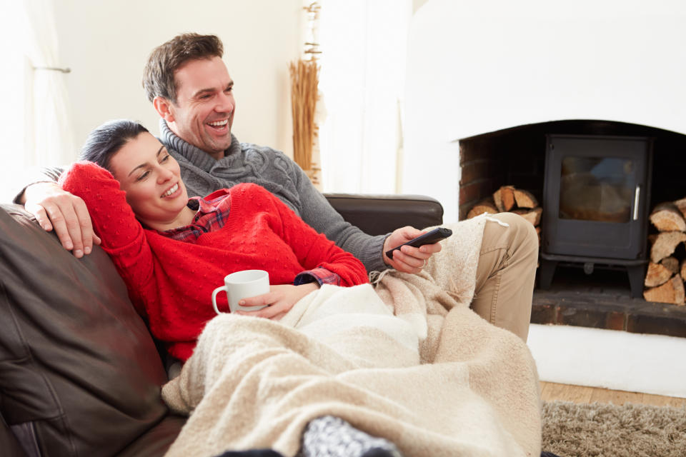 Couple relaxing at home watching TV smiling