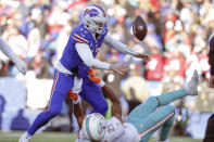 Buffalo Bills quarterback Josh Allen (17), top, loses control of the ball after a hit by Miami Dolphins safety Eric Rowe (21) during the second half of an NFL wild-card playoff football game, Sunday, Jan. 15, 2023, in Orchard Park, N.Y. (AP Photo/Joshua Bessex)