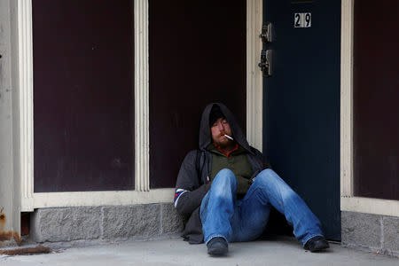 A man rests in a doorway on Court Street in Binghamton, New York, U.S., April 8, 2018. REUTERS/Andrew Kelly