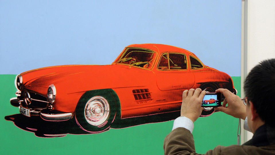 A visitor takes a photo of Andy Warhol's  Mercedes-Benz 300 SL Coupe (1954) at the Albertina museum, in Vienna, Austria, Thursday, Jan. 21, 2010. Under the title "Cars" the Albertina museum is showing an exhibition from the artists Andy Warhol, Sylvie Fleury, Robert Longo and Vincent Szarek. (AP Photo/Ronald Zak)