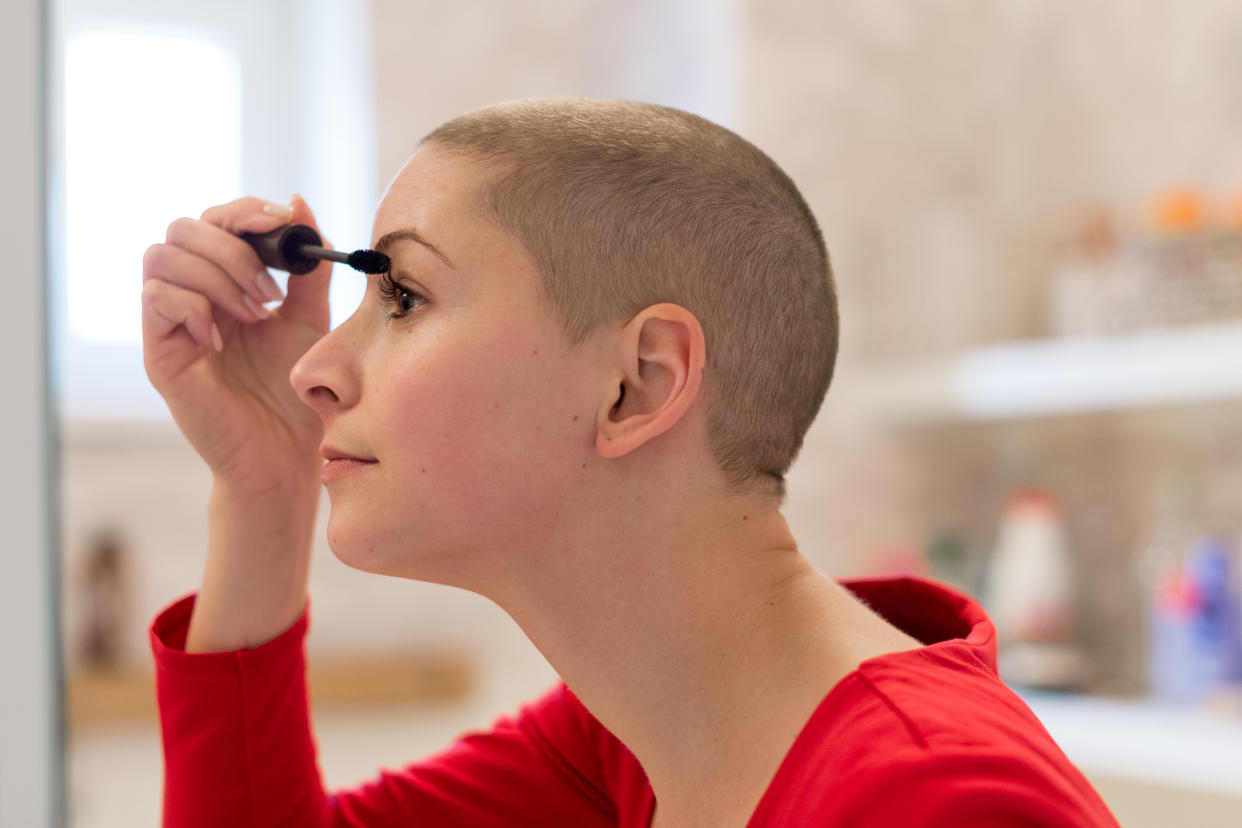 Eine Krebspatienten trägt sich Wimperntusche auf. Welche Produkte aber geeignet sind und wie man sich schminkt, wenn eine Chemotherapie alle Haare ausfallen lässt, lernen Krebspatienten in speziellen Kursen. Foto: Symbolbild / gettyimages / AndreaObzerova