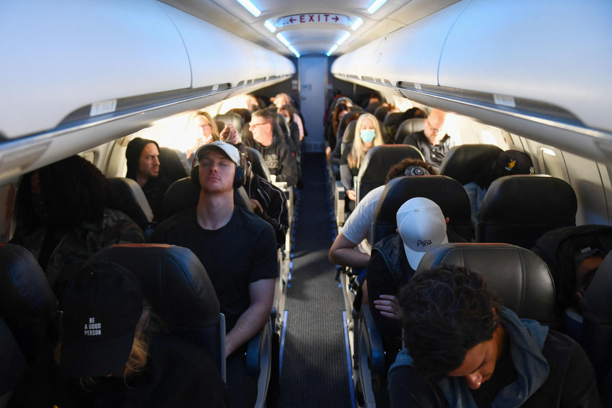 Airline passengers sit during a American Airlines flight operated by SkyWest Airlines from Los Angeles International Airport (LAX) to Denver on April 19, 2022. AFP/Patrick T. FALLON