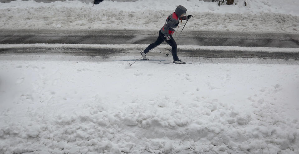 A cross-country skier glides on slushy snow on Brooklyn's Livingston Street, Tuesday March 14, 2017, in New York. (AP Photo/Bebeto Matthews)