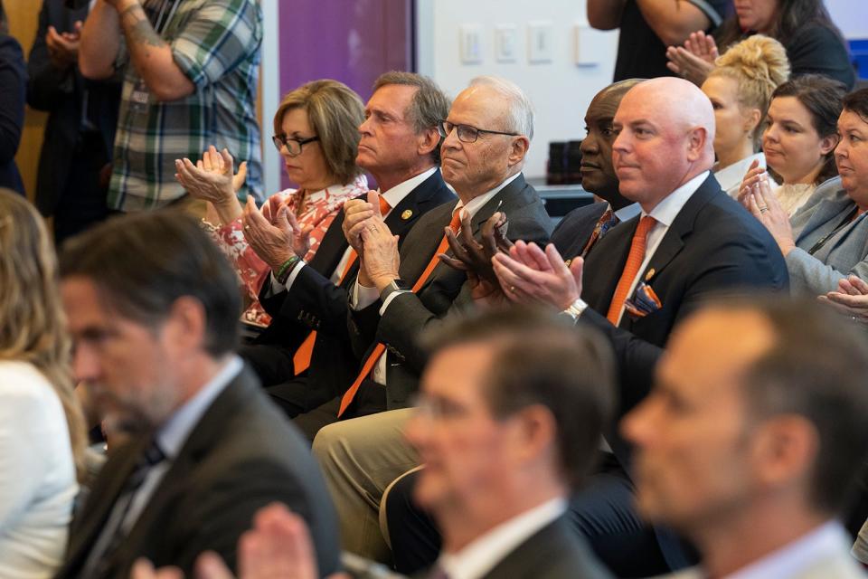 Attendees clap as the hospital plans are revealed during a news conference at the UT System's headquarters in downtown Austin..