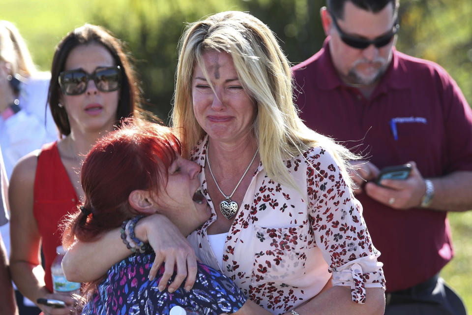 FILE - In this Feb. 14, 2018 file photo, parents wait for news after a report of a shooting at Marjory Stoneman Douglas High School in Parkland, Fla. Sorrow is reverberating across the country Sunday, Feb. 14, 2021, as Americans joined a Florida community in remembering the 17 lives lost three years ago in the Parkland school shooting massacre. President Joe Biden used the the occasion to call on Congress to strengthen gun laws, including requiring background checks on all gun sales and banning assault weapons. (AP Photo/Joel Auerbach, File)