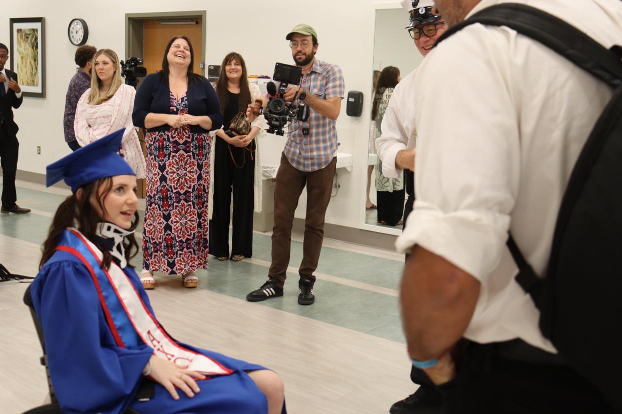 Teri Francois, the mother of MacKenzie Maier, laughs as her daughter talks June 23 with a member of Refried Confuzion, a brass band that played at her delayed graduation from Louisiana Tech University.