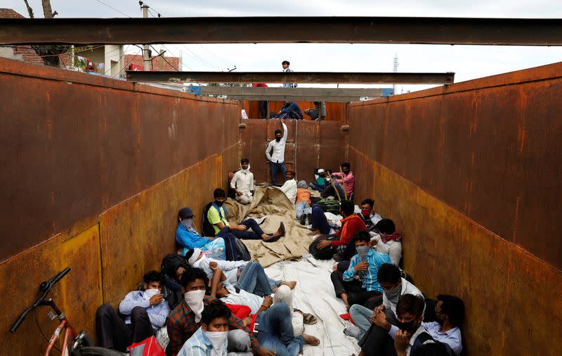 Migrant workers and their families board a truck to return to their villages during a 21-day nationwide lockdown to limit the spreading of coronavirus disease (COVID-19), in Simbhaoli