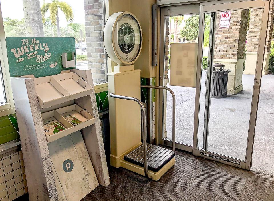 An old-fashioned scale on which people can stand and weigh themselves greets visitors at the entrance to the Publix store at 13880 Wellington Trace, on the southeast corner of Greenview Shores Boulevard and Wellington Trace. The store will close Saturday, July 8, 2023, for crews to demolish the building and expand the store's footprint in the Courtyard Shops plaza.