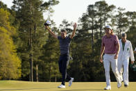 Scottie Scheffler celebrates as walks next to Cameron Smith, of Australia, after winning the 86th Masters golf tournament on Sunday, April 10, 2022, in Augusta, Ga. (AP Photo/David J. Phillip)