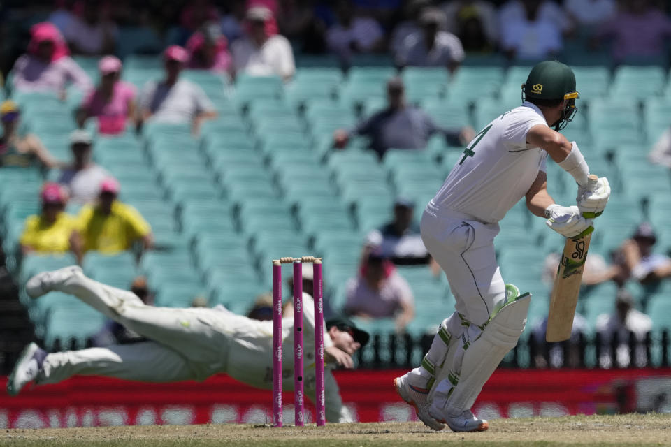 South Africa's Dean Elgar, right, turns to watch Australia's Steve Smith attempt to catch him out during the fifth day of their cricket test match at the Sydney Cricket Ground in Sydney, Sunday, Jan. 8, 2023. (AP Photo/Rick Rycroft)