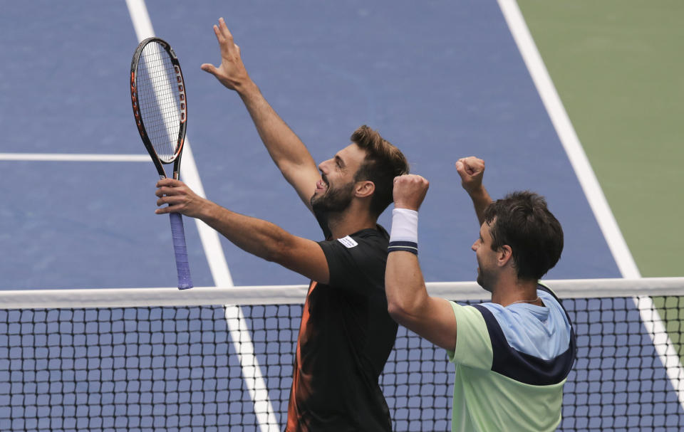 Marcel Granollers, of Spain, left, and doubles partner Horacio Zeballos, of Argentina, react after winning a semifinal doubles match against Kevin Kawietz and Andreas Mies, of Germany, at the U.S. Open tennis championships Thursday, Sept. 5, 2019, in New York. (AP Photo/Charles Krupa)