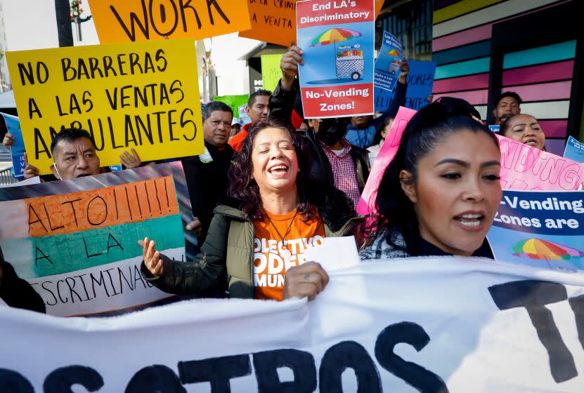 HOLLYWOOD-CA - DECEMBER 8, 2022: Eva Garcia, center, joins street Vendors and supporters on Hollywood's Walk of Fame to demonstrate against an LA city ordinance created of eight citywide no vending zones, on Thursday, December 8, 2022. (Christina House / Los Angeles Times)