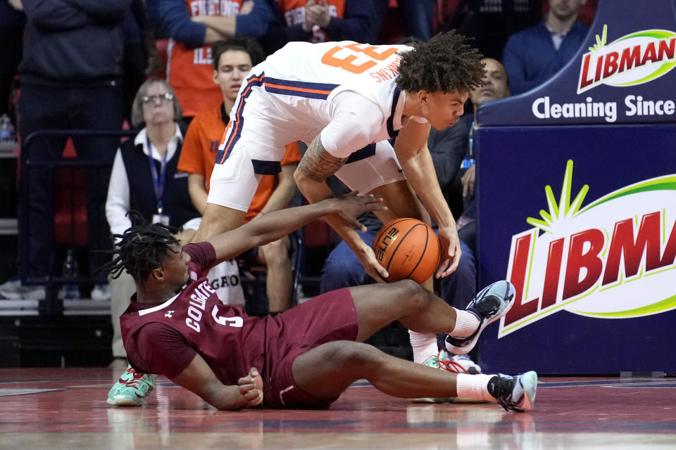 Illinois' Coleman Hawkins (33) grabs a loose ball from Colgate's Nicolas Louis-Jacques during the first half of an NCAA college basketball game Sunday, Dec. 17, 2023, in Champaign, Ill. (AP Photo/Charles Rex Arbogast)