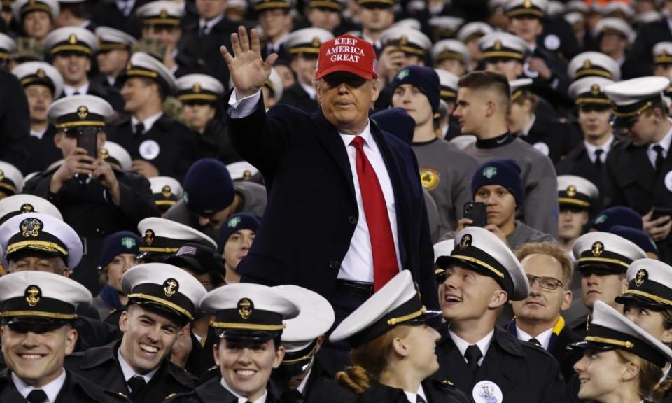 Donald Trump waves as he sits with Navy midshipmen in Philadelphia.