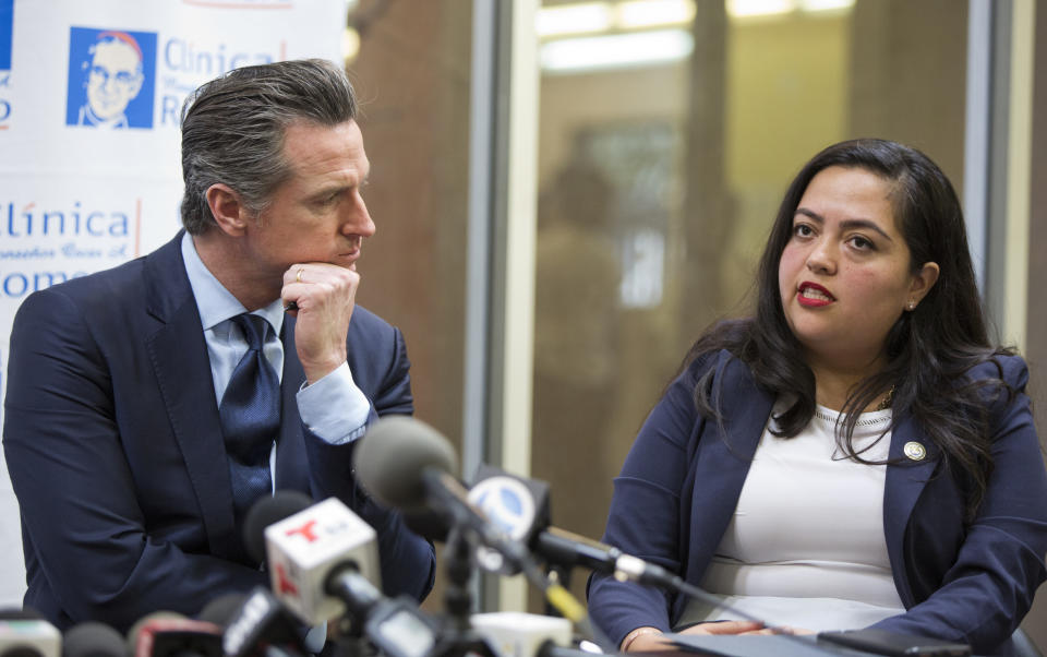 California Gov. Gavin Newsom, left, listens to Assemblymember Wendy Carrillo representing the 51st California Assembly District during a roundtable discussion with Central American community leaders at the Clinica Monsenor Oscar Romero in Los Angeles Thursday, March 28, 2019. The roundtable examines the root causes of migration and discusses California's efforts to provide relief and humanitarian aid to asylum seekers fleeing poverty and violence in their home countries. (AP Photo/Damian Dovarganes)