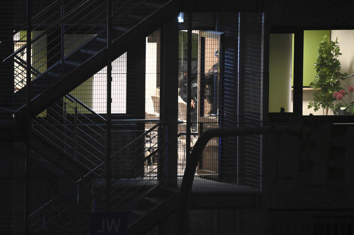 Police officers in special equipment walk through a Jehovah's Witness building in Hamburg, Germany, Thursday, March 9, 2023. German police say shots were fired inside the building used by Jehovah’s Witnesses and an unspecified number of people were killed or wounded. (Jonas Walzberg/dpa via AP)