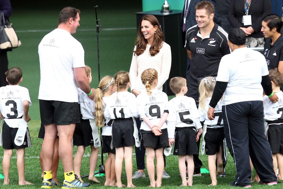 <p>Middleton attends a kid's rugby game in Australia. She's seen here laughing along with the little rugby players and their coach.</p>