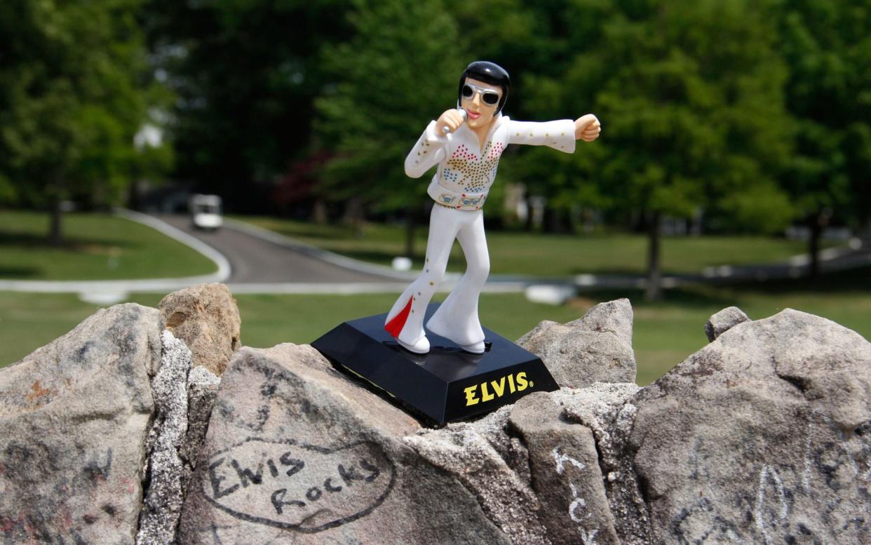 Graffiti and souvenirs adorn a wall outside Graceland, where Elvis lived - ALAMY