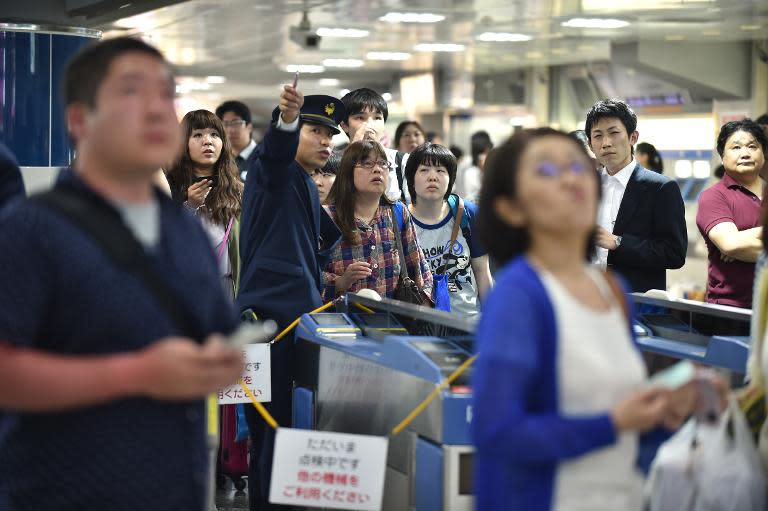 Passengers wait for 'Shinkansen' bullet train operations to resume at a station in Tokyo following an earthquake, on May 30, 2015