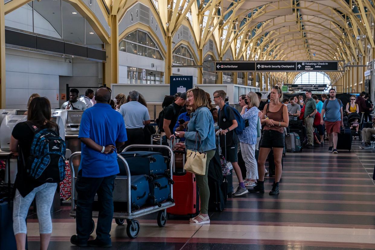 Travelers wait to check their bags at Ronald Regan Washington National Airport on July 11, 2022 in Arlington, Virginia.