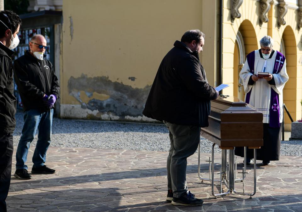 Un sacerdote celebra un funeral sin familiares dentro del cementerio de Zogno, al norte de Italia. (PIERO CRUCIATTI/AFP via Getty Images)