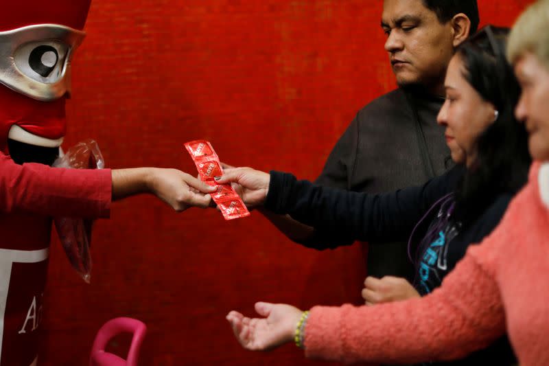 A man wearing a condom costume gives out free condoms inside the metro on International Condoms Day, celebrated a day before Valentine Day, in Mexico City