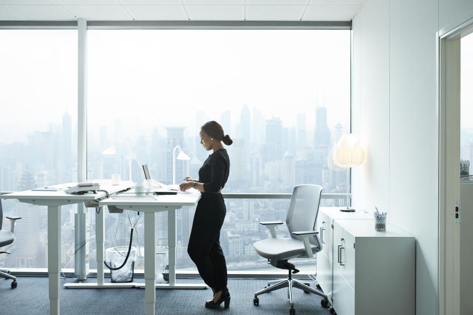 Elegant businesswoman working alone with laptop in office building