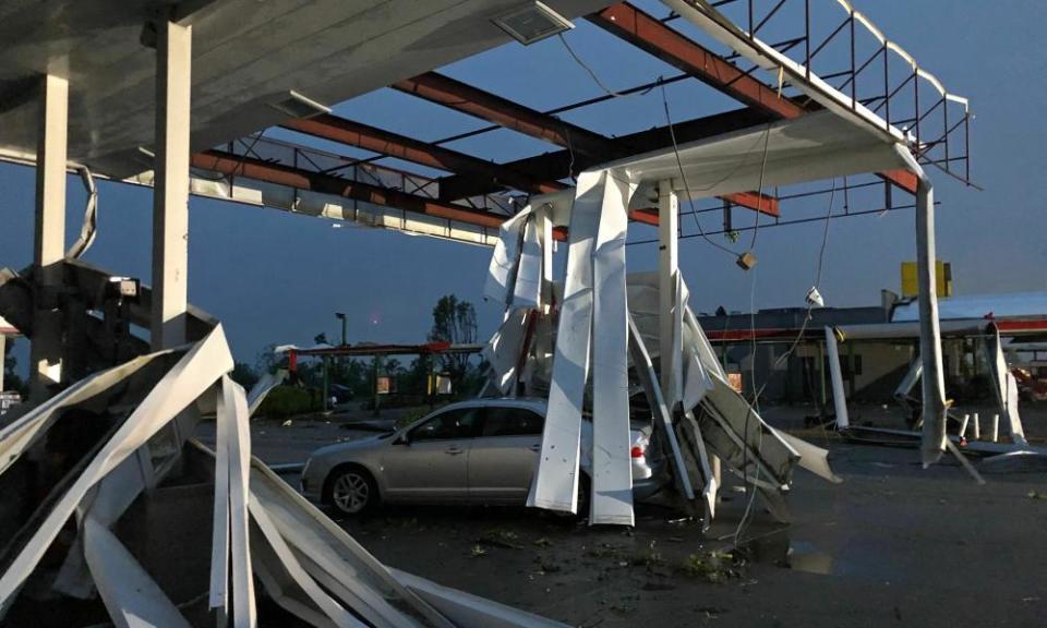 A car is trapped under the fallen metal roof of the Break Time gas station and convenience store in Jefferson City, Missouri.