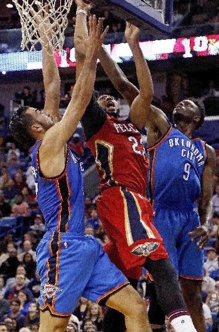 New Orleans Pelicans forward Anthony Davis, center, attempts to make a layup against Oklahoma City Thunder center Joffrey Lauvergne, left, and forward Jerami Grant, right, during the first half of an NBA basketball game in New Orleans, Wednesday, Dec. 21, 2016. (AP Photo/Max Becherer)