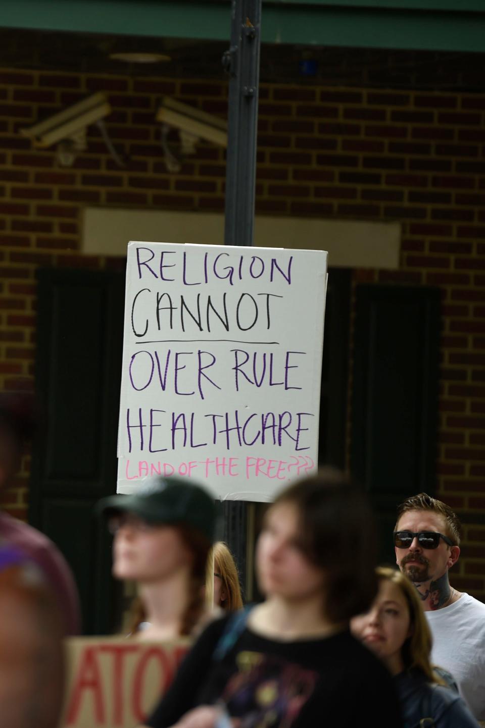 A sign is held over the crowd during the Reproductive Rights Protesting, Augusta rally at the Augusta Common on Saturday, May 21, 2022.