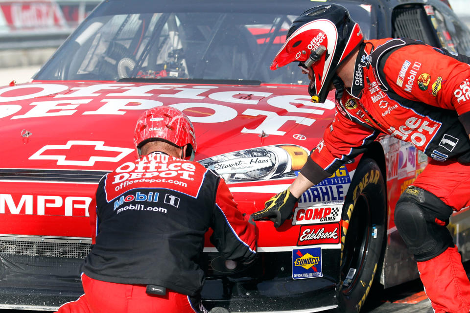 HOMESTEAD, FL - NOVEMBER 20: Crew members work on the #14 Office Depot/Mobil 1 Chevrolet driven by Tony Stewart after Stewart pits after sustaining damage to the front end of his car during the start of the NASCAR Sprint Cup Series Ford 400 at Homestead-Miami Speedway on November 20, 2011 in Homestead, Florida. (Photo by Todd Warshaw/Getty Images for NASCAR)