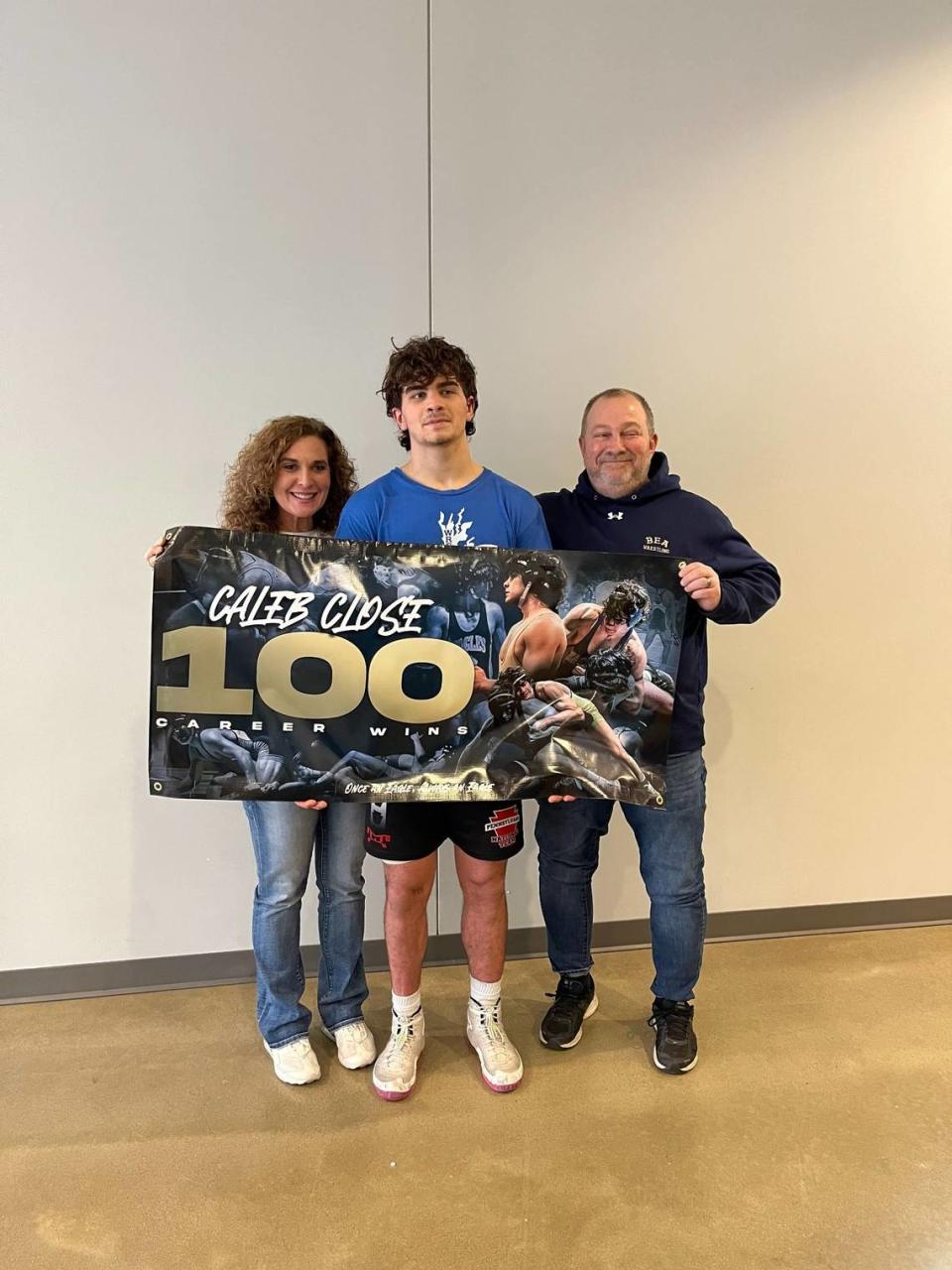 Bald Eagle Area’s Caleb Close celebrates collecting his 100th career win with his parents, Marilee and David. Close pinned Thomas Jefferson’s Zach Labryer in 1:43 of their first round match of the Mid Winter Mayhem on Friday.