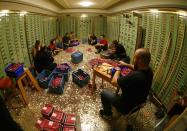 Committee members for the initiative "CHF 2,500 monthly for everyone" (Grundeinkommen) open rolls of five cent coins in the old vault of the former Schweizerische Volksbank in Basel October 1, 2013. The committee dumped 8,000,000 five cent coins, weighting 15 tones, over the Federal Square in Bern on Friday, before delivering 126,000 signatures to the Chancellery to propose a change in the constitution to implement their initiative. The initiative aims to have a minimum monthly disposal household income of CHF 2,500 (US$ 2,700) given by the government to every citizen living in Switzerland. Picture taken with a fisheye and October 1, 2013. REUTERS/Ruben Sprich (SWITZERLAND - Tags: POLITICS CIVIL UNREST TPX IMAGES OF THE DAY)