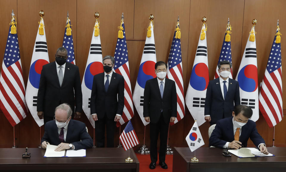 Robert Rapson, Chargé d'Affaires ad interim at U.S. Embassy, left sit, and South Korea's chief negotiator Jeong Eun-bo, right sit, initial as U.S. Secretary of State Antony Blinken, second from left, U.S. Defense Secretary Lloyd Austin, left, South Korean Foreign Minister Chung Eui-yong, second from right, and South Korean Defense Minister Suh Wook, right, clap during an initialing ceremony for Special Measures Agreement at the Foreign Ministry in Seoul, South Korea, Thursday, March 18, 2021. (AP Photo/Lee Jin-man, Pool)