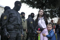 A woman with her child react as police officers detain protesters during a rally in support of Maria Kolesnikova, a member of the Coordination Council created by the opposition to facilitate talks with Lukashenko on a transition of power, was detained Monday in the capital of Minsk with two other council members, in Minsk, Belarus, Tuesday, Sept. 8, 2020. A leading opposition activist in Belarus is being held on the border with Ukraine after she resisted attempts by authorities to deport her from the country as part of a clampdown on protests against authoritarian President Alexander Lukashenko. (AP Photo)