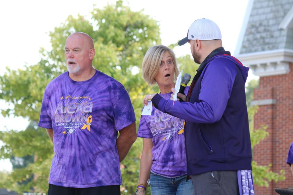 Warren and Wendy Brown speak with John Walsh at a previous Alexa Memorial 5K Run. The run for 2023 will be Saturday at 8 a.m.