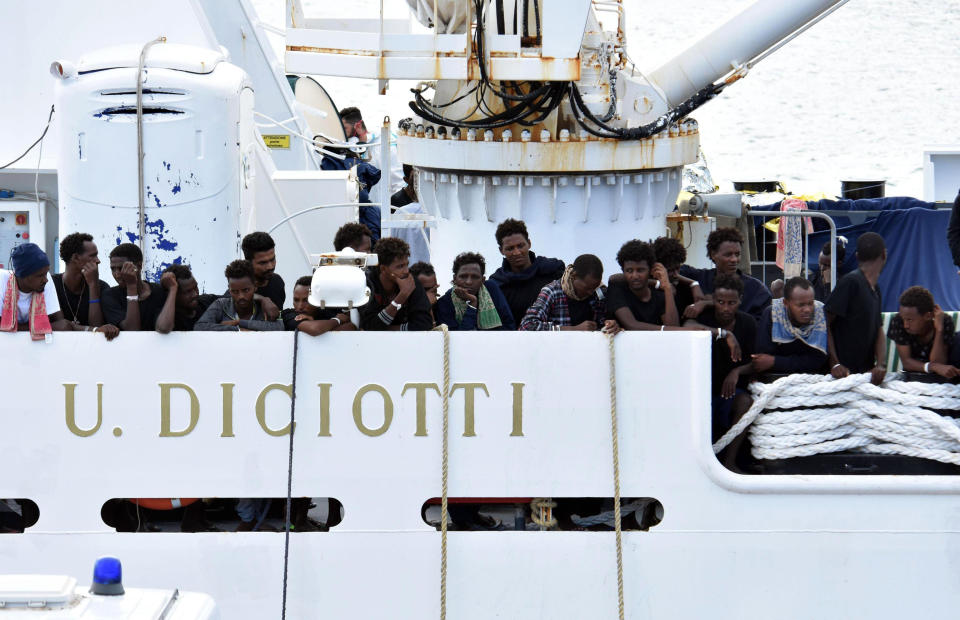 Migrants aboard the Italian Coast Guard ship Diciotti gather on the deck as they await decisions in the port of Catania, Italy, Friday, Aug. 24 2018. An Italian lawmaker says rescued migrants stuck aboard an Italian coast guard ship are starting a hunger strike. Rescued on Aug. 16 in the Mediterranean Sea, 150 migrants are still on the ship after minors and the sick were allowed off in recent days. (Orietta Scardino/ANSA via AP)
