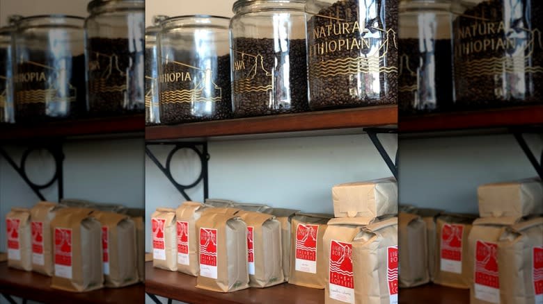 Bags and glass containers of coffee beans on shelves