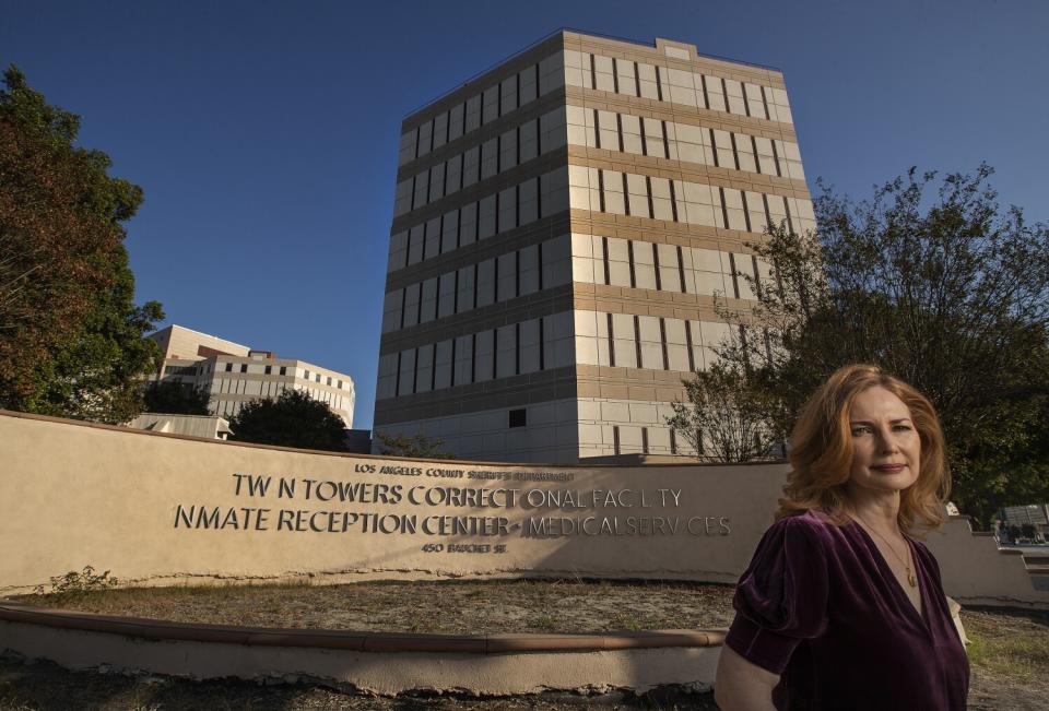 A woman standing for a portrait in front of the Twin Towers jail building.