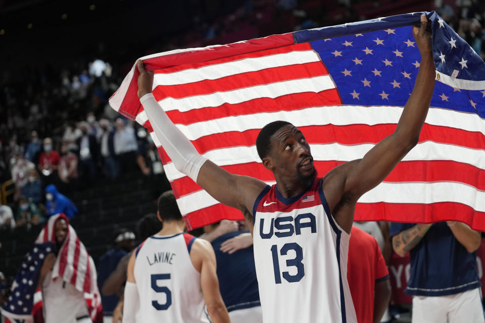 United States' Bam Adebayo (13) waves the United States flag as he celebrates with teammates after their win over France in a men's basketball Gold medal game at the 2020 Summer Olympics, Saturday, Aug. 7, 2021, in Saitama, Japan. (AP Photo/Eric Gay)