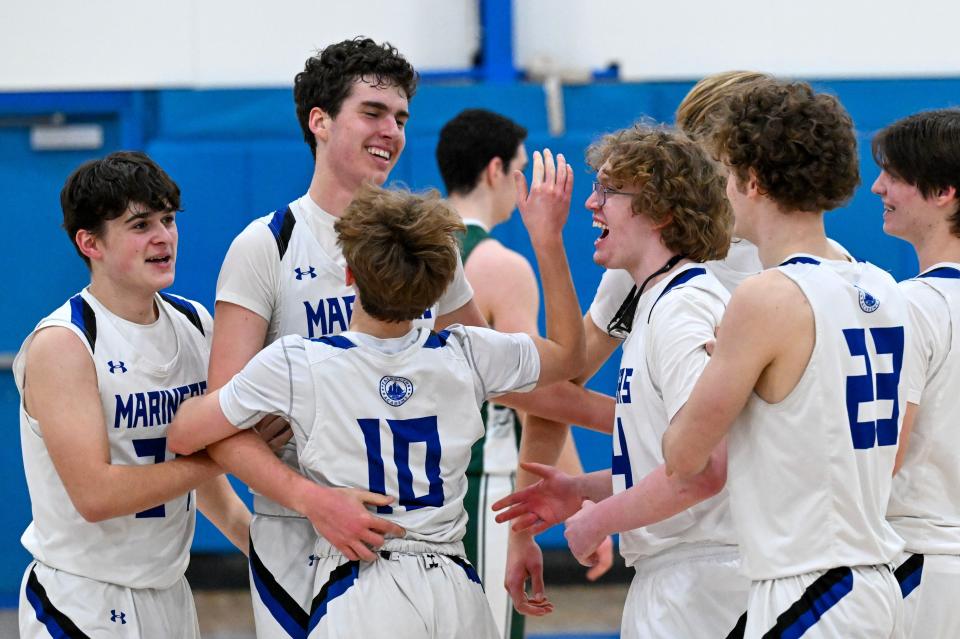 In this Feb. 16 photo, Nate Holmes (second from left) celebrates with his Falmouth Academy after reaching 1,000 career points during the game with Sturgis West.