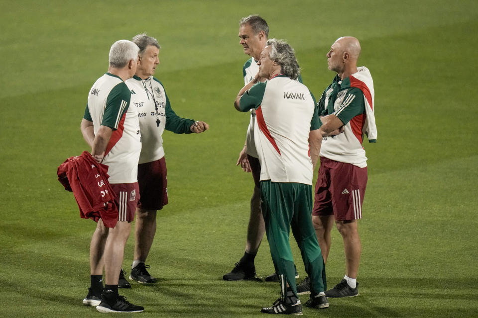 El técnico de México Gerardo Martino charla con sus asistentes durante un entrenamiento en Jor, Qatar, el sábado 19 de noviuembre de 2022. (AP Foto/Moisés Castillo)