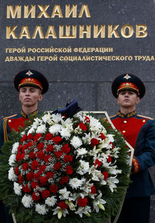 Guards of honour stand next to a monument to Mikhail Kalashnikov, the Russian designer of the AK-47 assault rifle, during its opening ceremony in Moscow, Russia September 19, 2017. REUTERS/Sergei Karpukhin