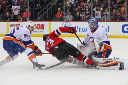 Feb 7, 2019; Newark, NJ, USA; New Jersey Devils center Nico Hischier (13) crashes into New York Islanders goaltender Thomas Greiss (1) after a save by Greiss during the third period at Prudential Center. Mandatory Credit: Ed Mulholland-USA TODAY Sports