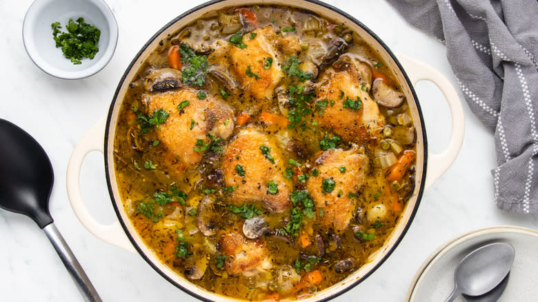 Chicken and vegetable casserole in pot with parsley