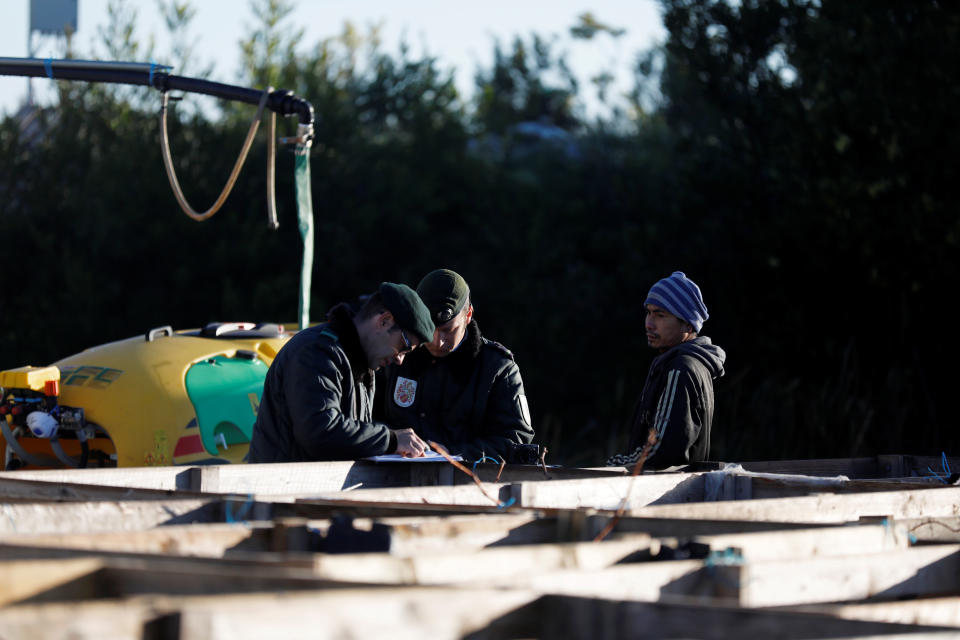 A Thai worker speaks with police officers during a labour conditions control at a red fruit farm near Odemira, Portugal February 7, 2019.  Picture taken February 7, 2019.  REUTERS/Rafael Marchante